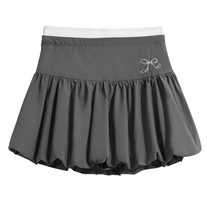 A coquette aesthetic grey mini skirt with a high-waist design and voluminous, pleated structure. The skirt features a puffy silhouette with a bubble hem for a unique look