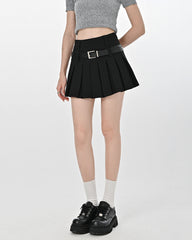 A cute pleated mini skirt featuring a high-waist design. It includes loops for two belts, adding a modern and edgy touch to the classic pleated silhouette