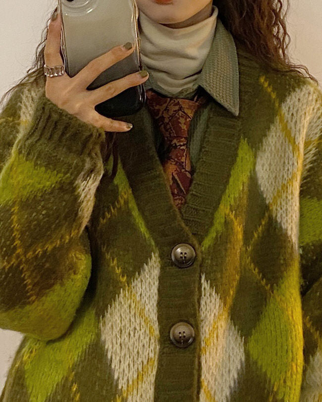 This vintage-inspired green oversized cardigan has a soft knit construction, an argyle pattern all over, front button closures, and long sleeves